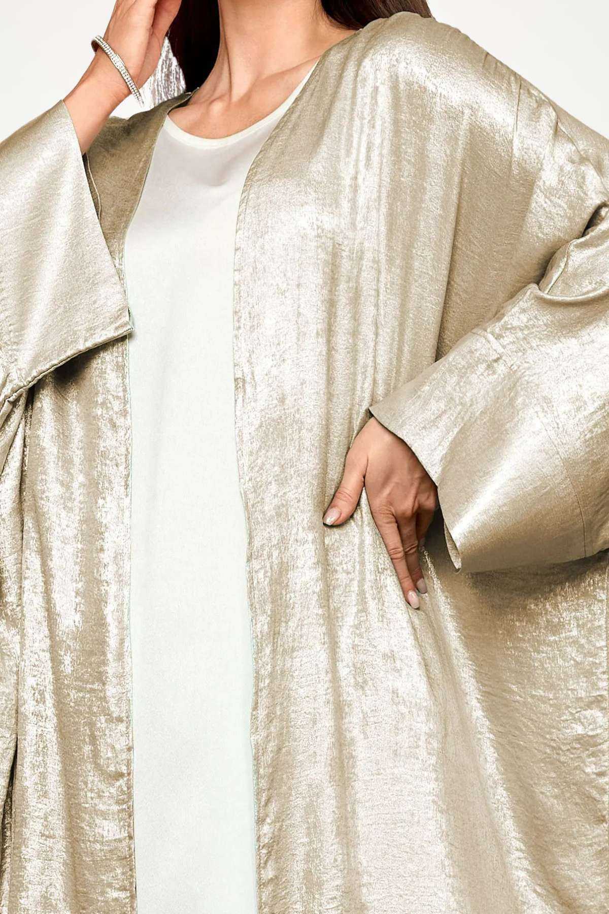 Abaya kimono luxe en velours satiné texturé beige. Coupe longue et fluide, finitions haut de gamme, pour une élégance affirmée et sans compromis.