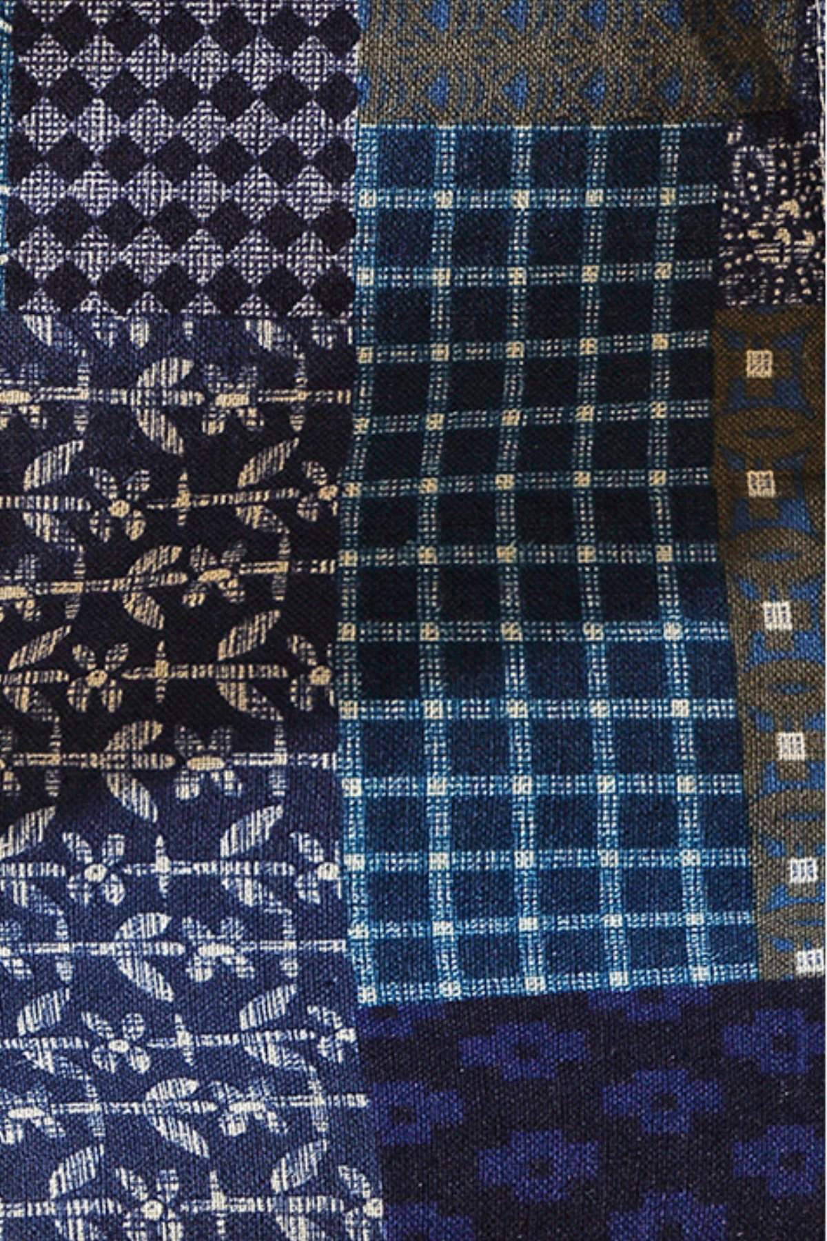 Tissu en patchwork avec motifs floraux et carreaux, dominé par des nuances de bleu et de noir