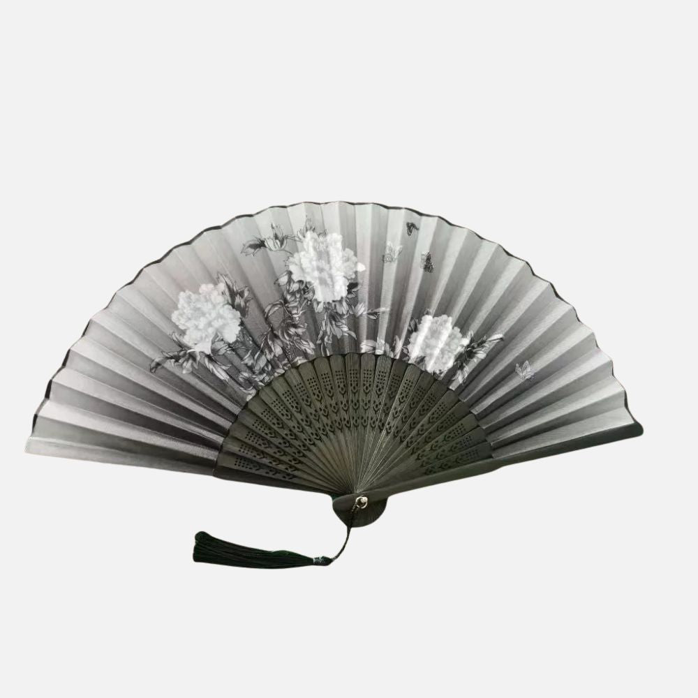 Éventail en papier noir et blanc avec motifs floraux, décoré d'un pompon, style japonais élégant