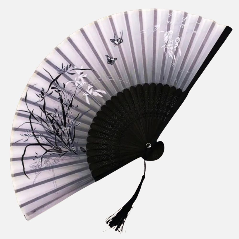 Éventail en papier noir et blanc avec motifs de fleurs et papillons, décoré d'une frange délicate