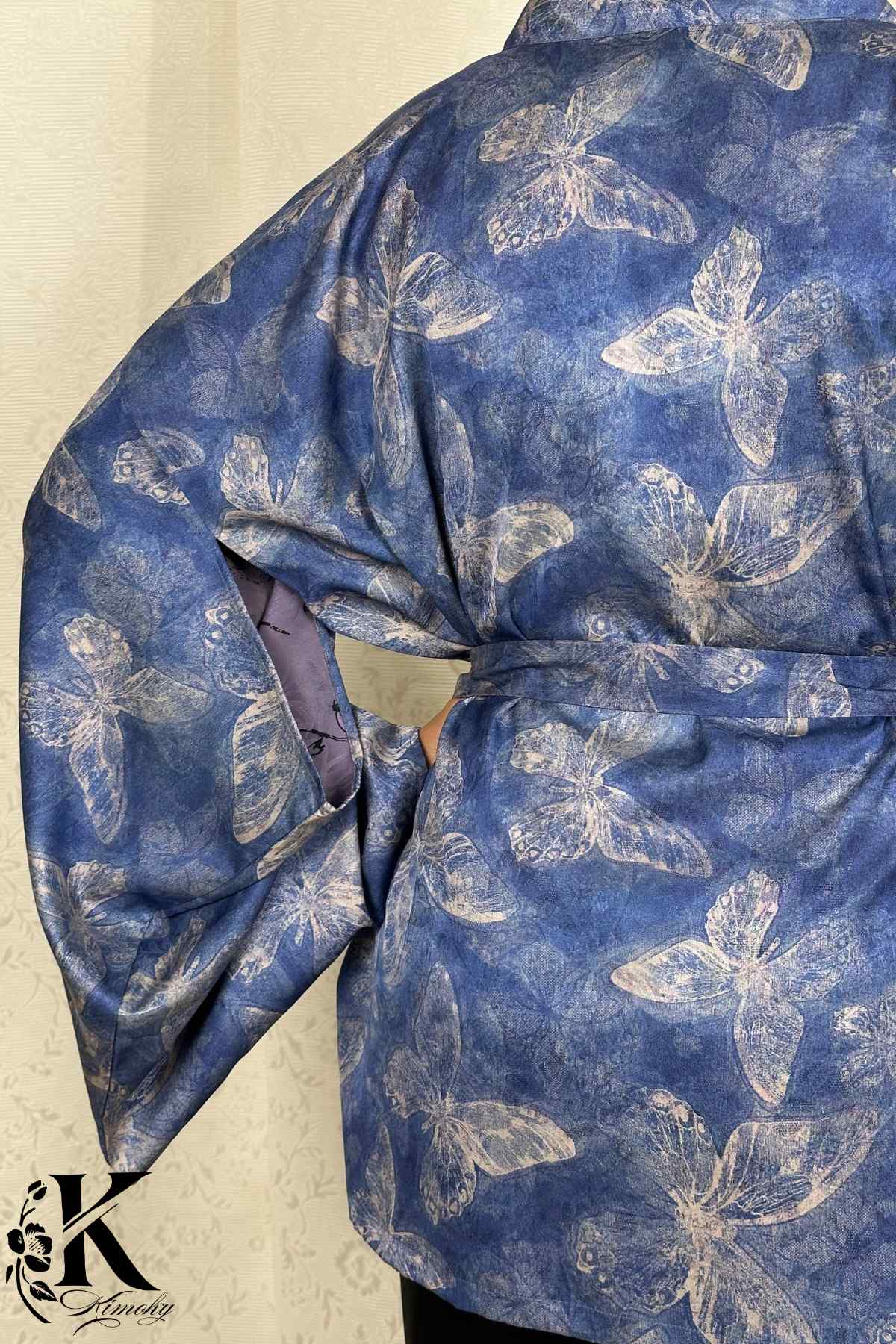 Kimono bleu avec motifs de papillons clairs, tissu fluide, manches larges et ceinture à la taille