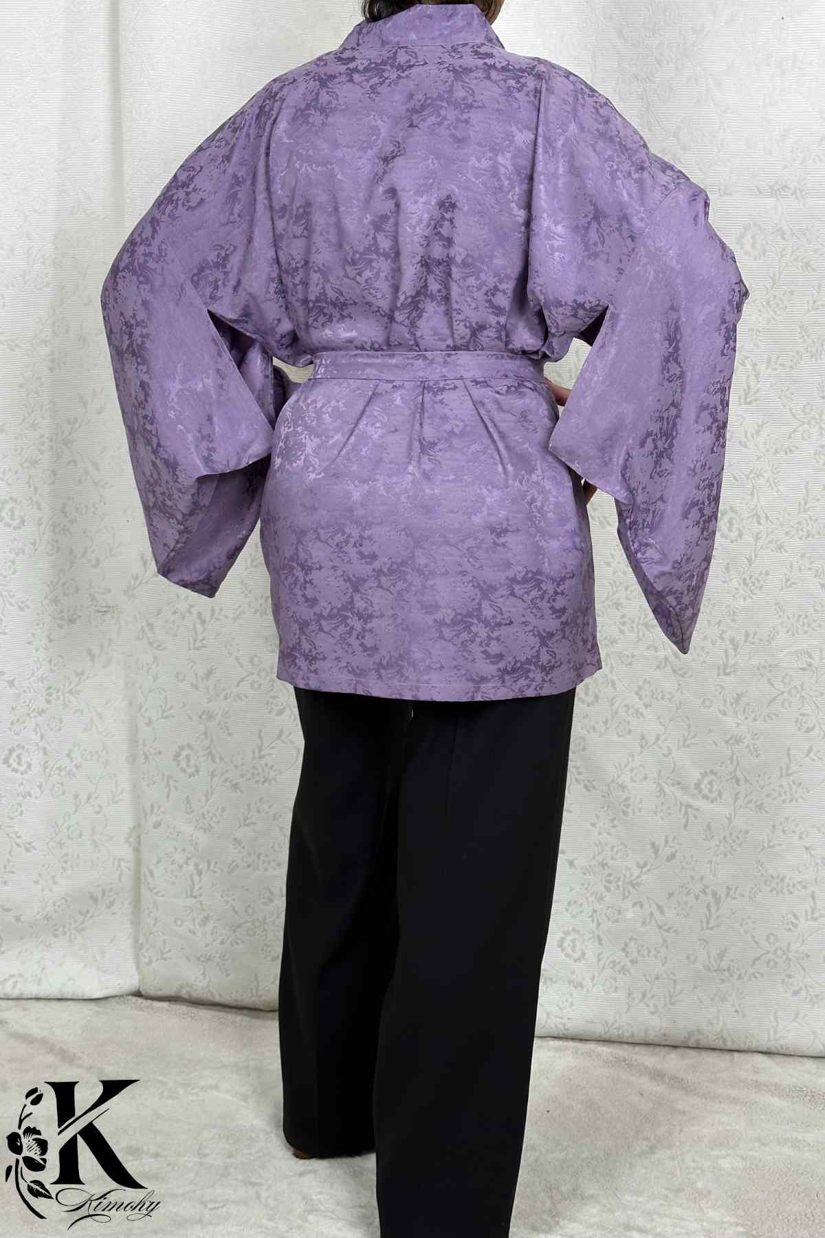 Veste kimono femme en satin violet avec motifs floraux, manches larges, portée sur un pantalon noir