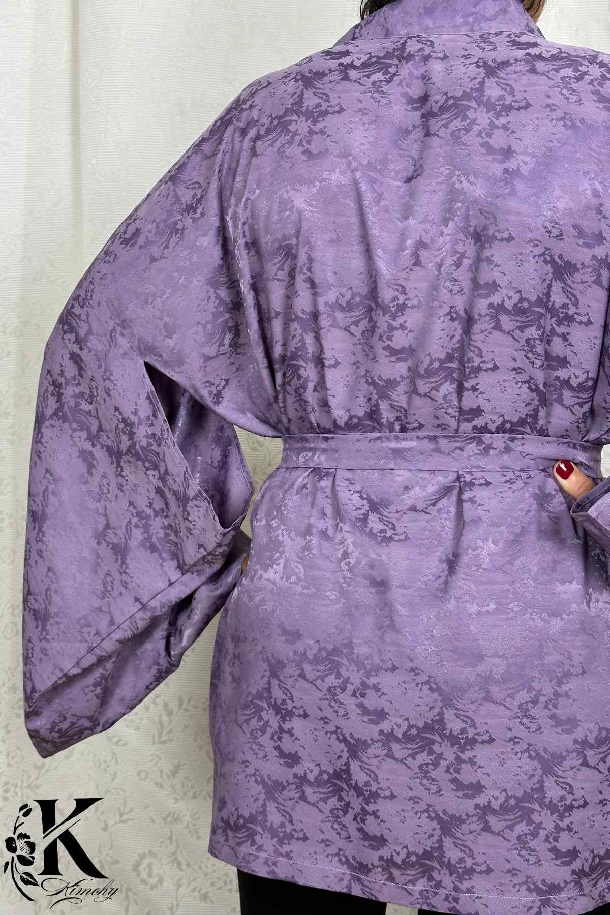 Veste kimono femme en satin violet avec motifs floraux, manches larges et ceinture, sur fond clair