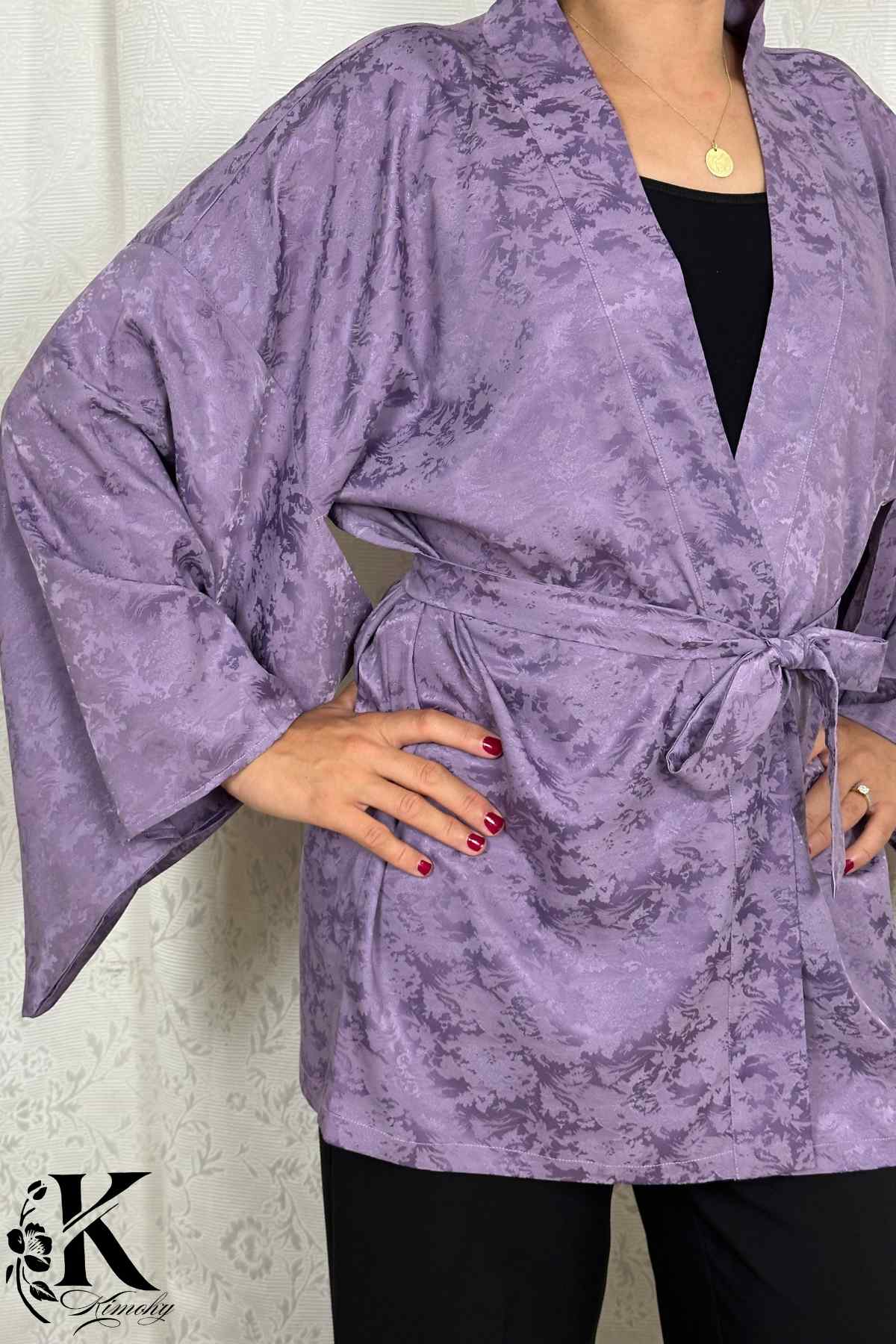 Veste kimono femme en tissu violet avec motifs subtils, ceinture nouée et manches larges, sur fond clair