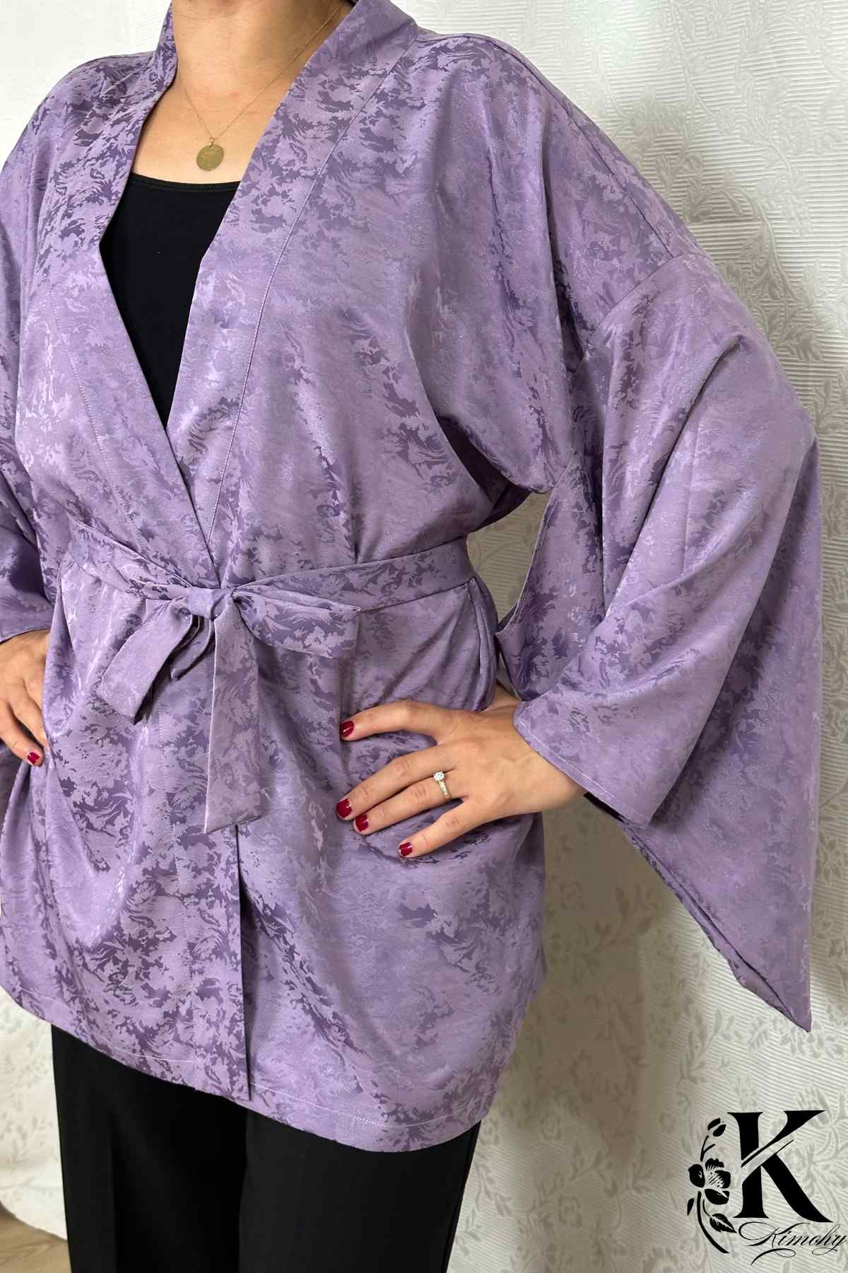 Veste kimono femme en satin violet avec motifs floraux subtils, portée avec un pantalon noir élégant