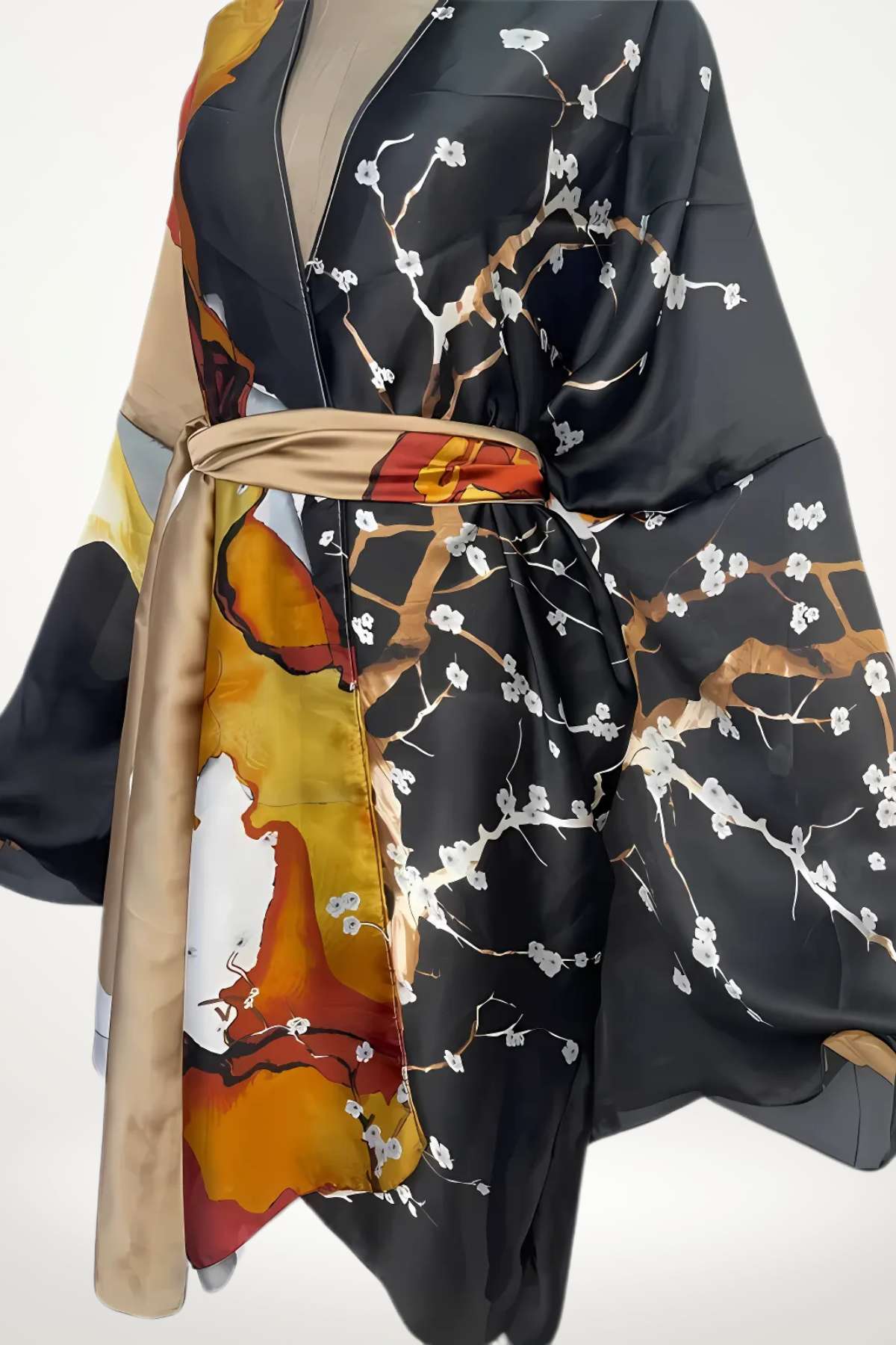 Kimono en satin noir avec motifs floraux blancs, touches orangées et dorées, ceinturé à la taille pour une élégance légère