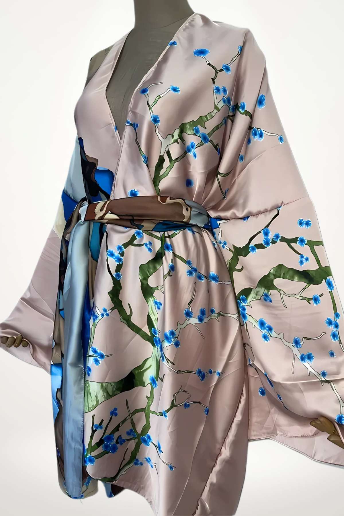 Kimono en satin rose avec motifs floraux bleus et verts, drapé élégamment sur un mannequin