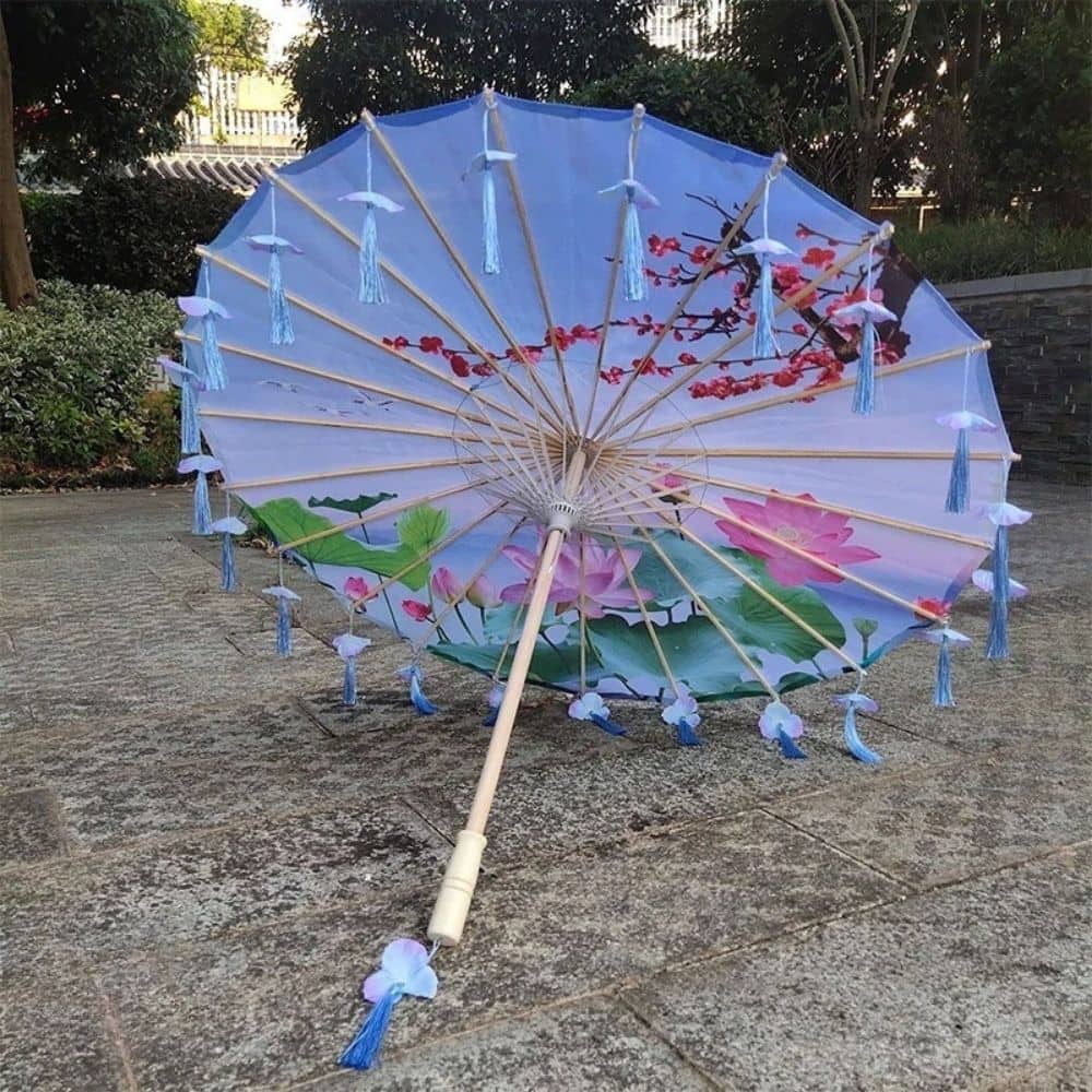 Ombrelle pliante avec motifs de fleurs de lotus, décorée de franges bleues sur un fond bleu clair