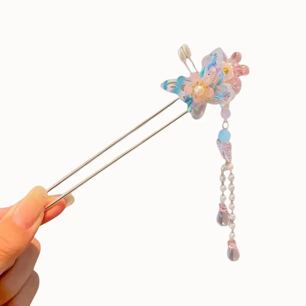 Bijou de cheveux à papillon bleu et gouttes de verre roses.
