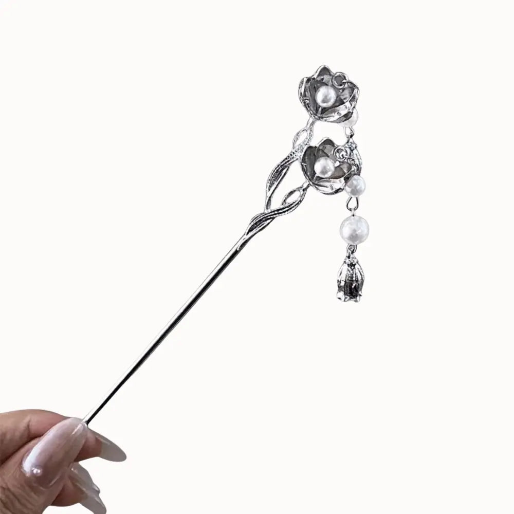 Épingle à cheveux argentée avec motif floral.