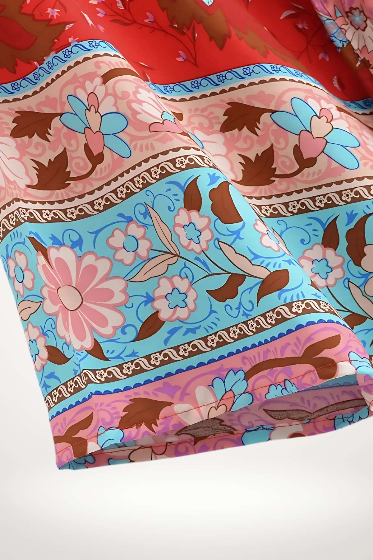 Haut kimono féminin aux motifs floraux colorés, dominé par des teintes rouges, roses et bleues, avec des détails élégants