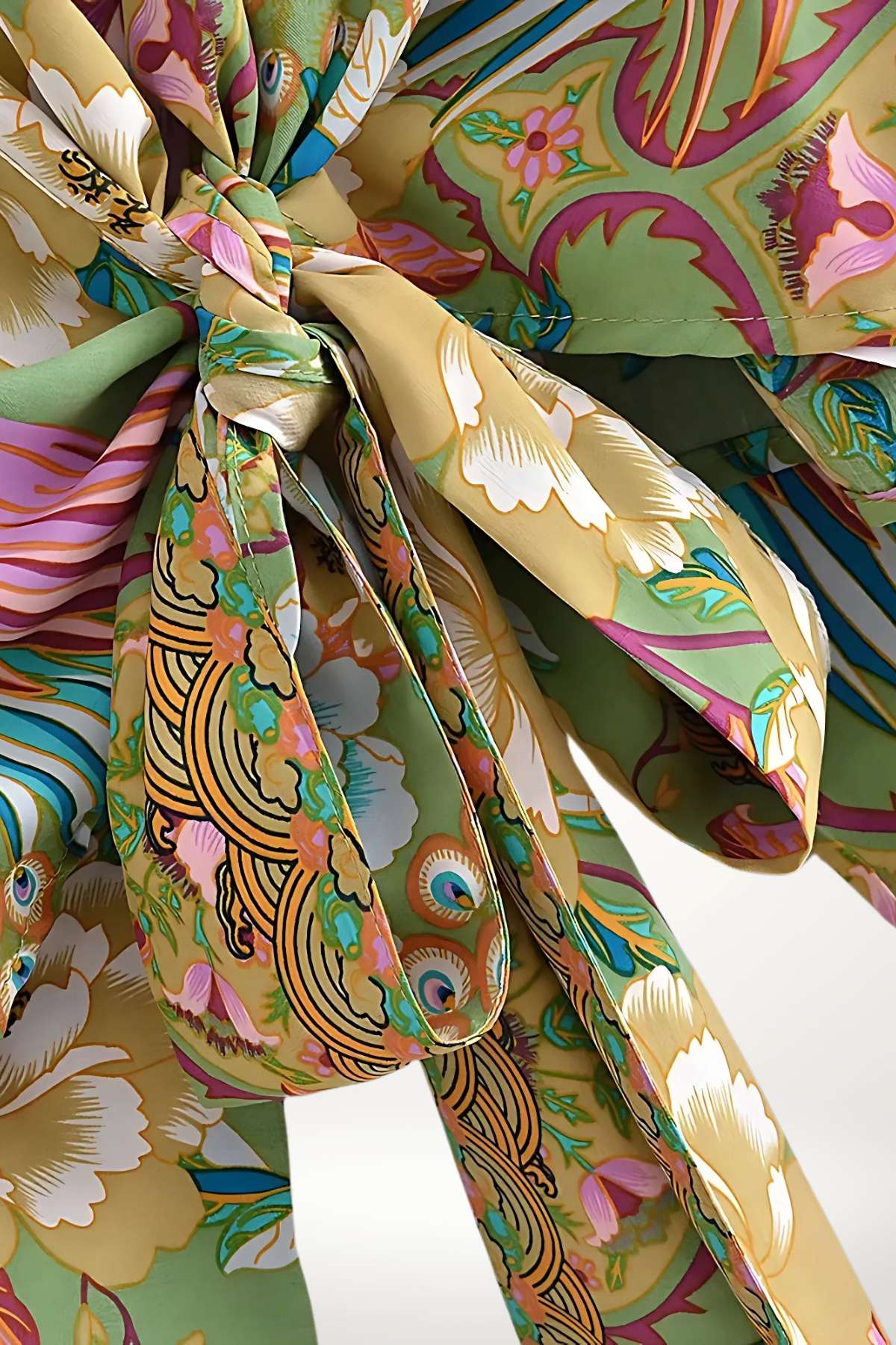 Un kimono aux motifs floraux colorés, dominé par des teintes vertes, roses et dorées, noué avec élégance