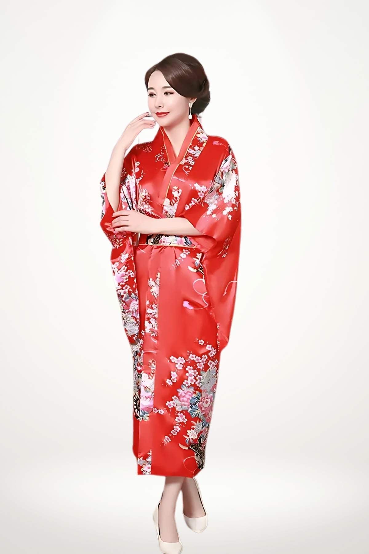 Femme debout portant un kimono long rouge et blanc en satin orné de motifs floraux japonais et ceinture obi tressée.