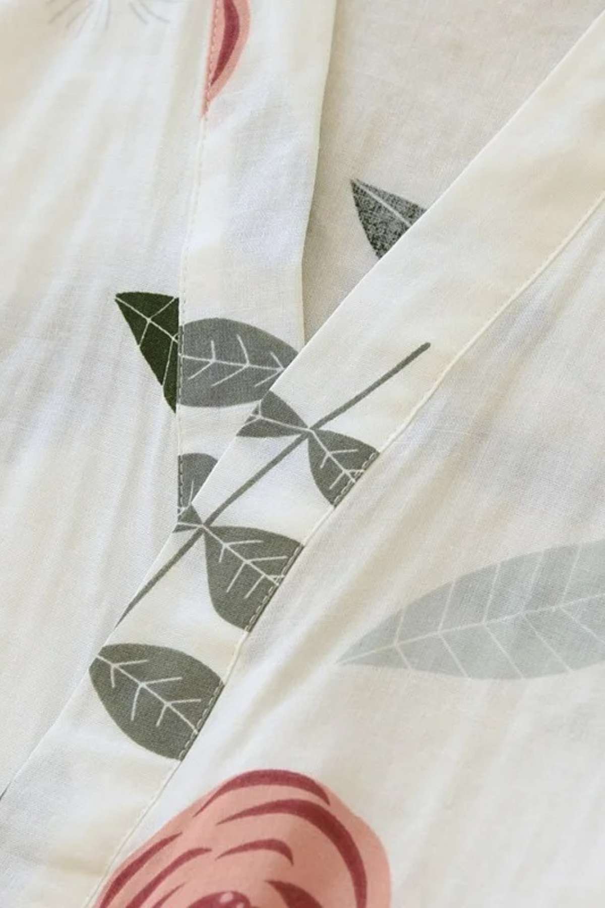 Tissu léger et doux avec motifs floraux roses et feuilles vertes sur fond blanc, style kimono délicat