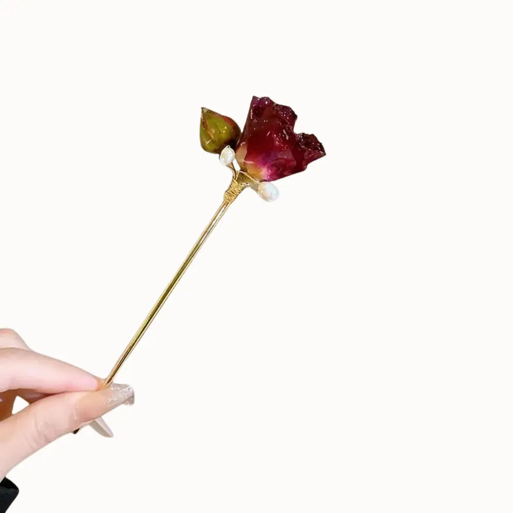 Peigne à cheveux orné d’une rose et de fils dorés.