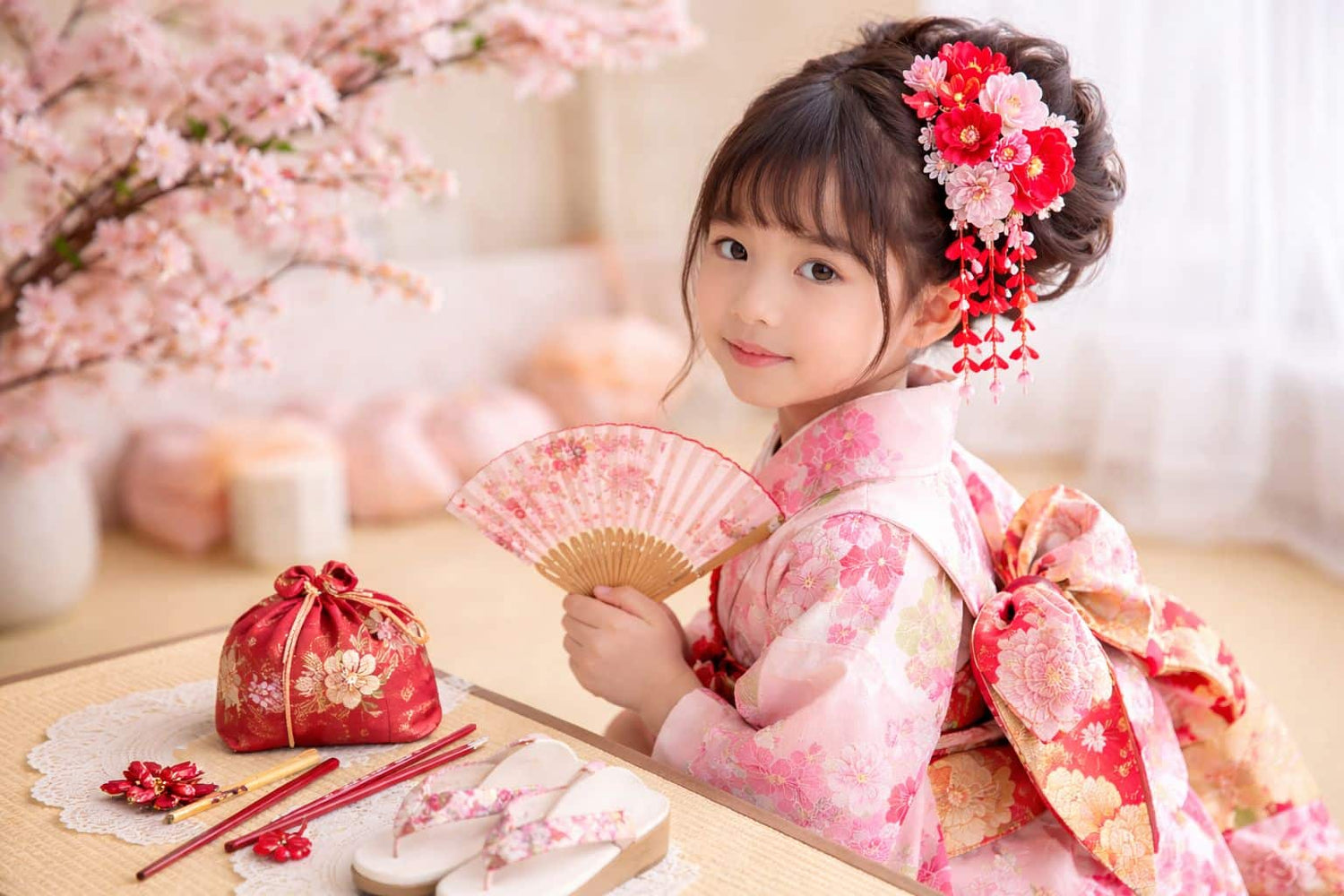 petite fille en kimono avec barrette dans les cheveux et éventail japonais dans la main