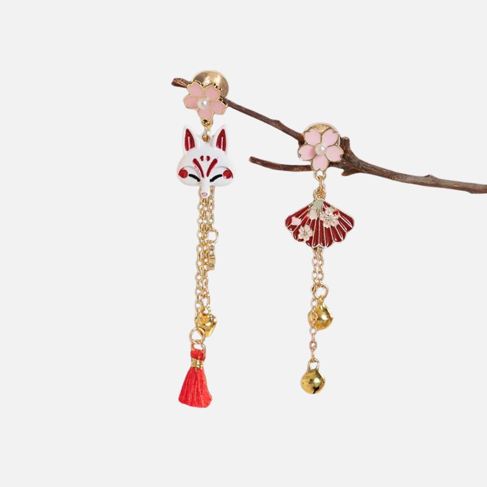 Boucles d'oreilles en métal doré ornées d'un renard stylisé et d'une fleur rose, avec des détails rouges et dorés.