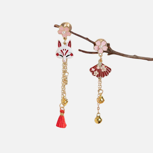 Boucles d'oreilles en métal doré ornées d'un renard stylisé et d'une fleur rose, avec des détails rouges et dorés.