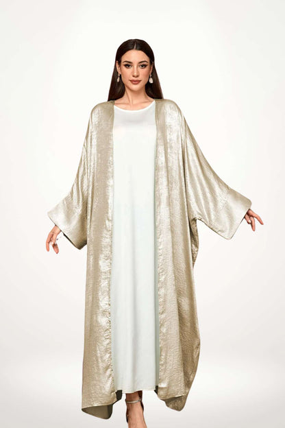Abaya kimono luxe en velours satiné texturé beige. Coupe longue et fluide, finitions haut de gamme, pour une élégance affirmée et sans compromis.