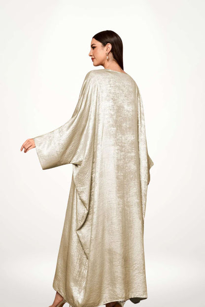 Abaya kimono luxe en velours satiné texturé beige. Coupe longue et fluide, finitions haut de gamme, pour une élégance affirmée et sans compromis.