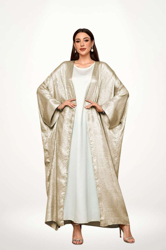 Abaya kimono luxe en velours satiné texturé beige. Coupe longue et fluide, finitions haut de gamme, pour une élégance affirmée et sans compromis.