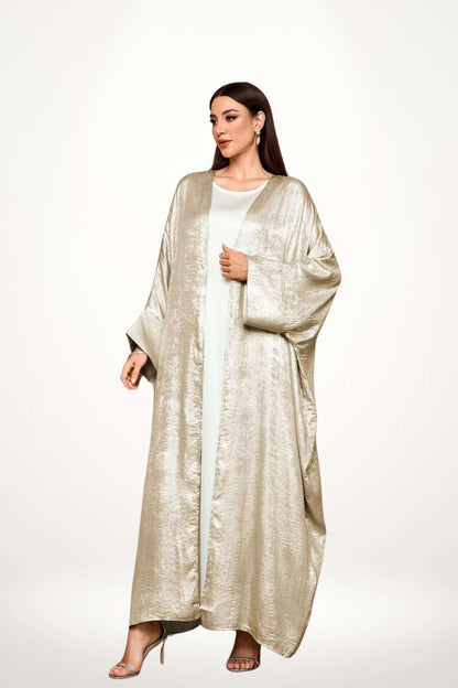 Abaya kimono luxe en velours satiné texturé beige. Coupe longue et fluide, finitions haut de gamme, pour une élégance affirmée et sans compromis.