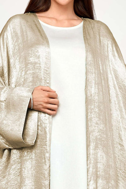 Abaya kimono luxe en velours satiné texturé beige. Coupe longue et fluide, finitions haut de gamme, pour une élégance affirmée et sans compromis.