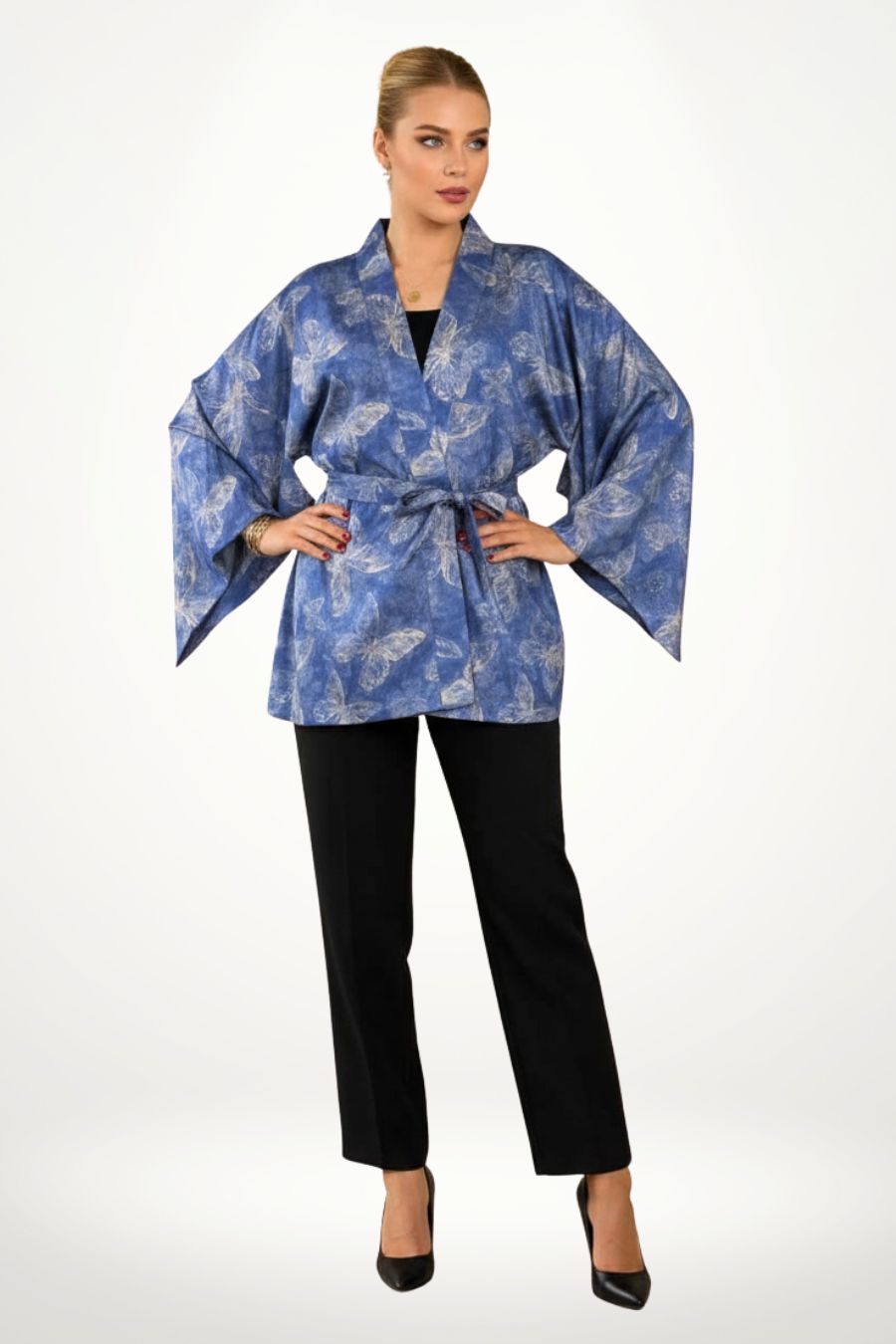 Kimono bleu avec motifs de papillons, manches larges, porté avec un pantalon noir sur fond clair