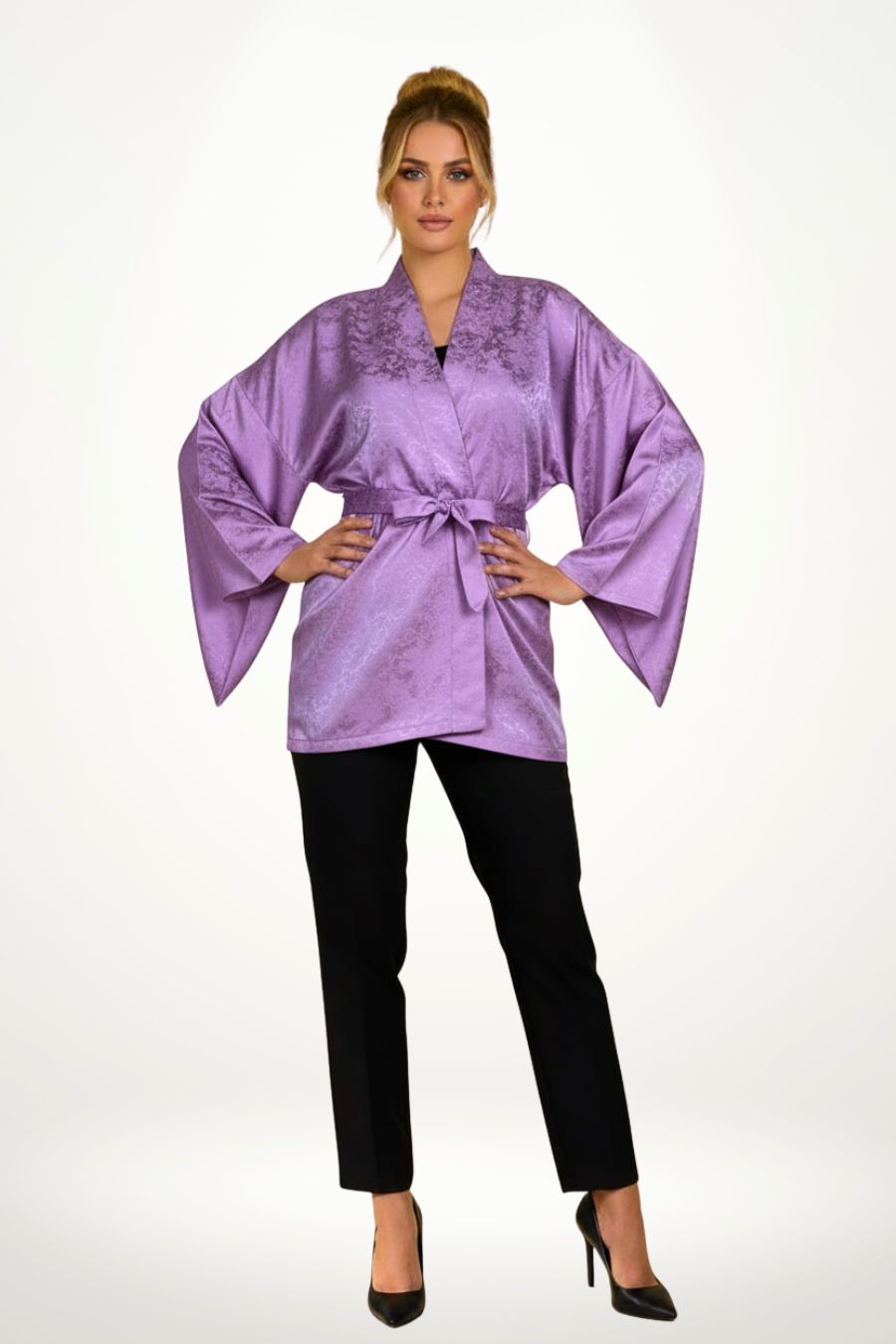 Veste kimono femme en tissu violet avec motifs subtils, portée avec un pantalon noir et un décor floral en arrière-plan