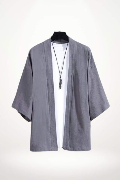 Un kimono moderne gris en tissu léger, avec des manches larges, porté sur un t-shirt blanc