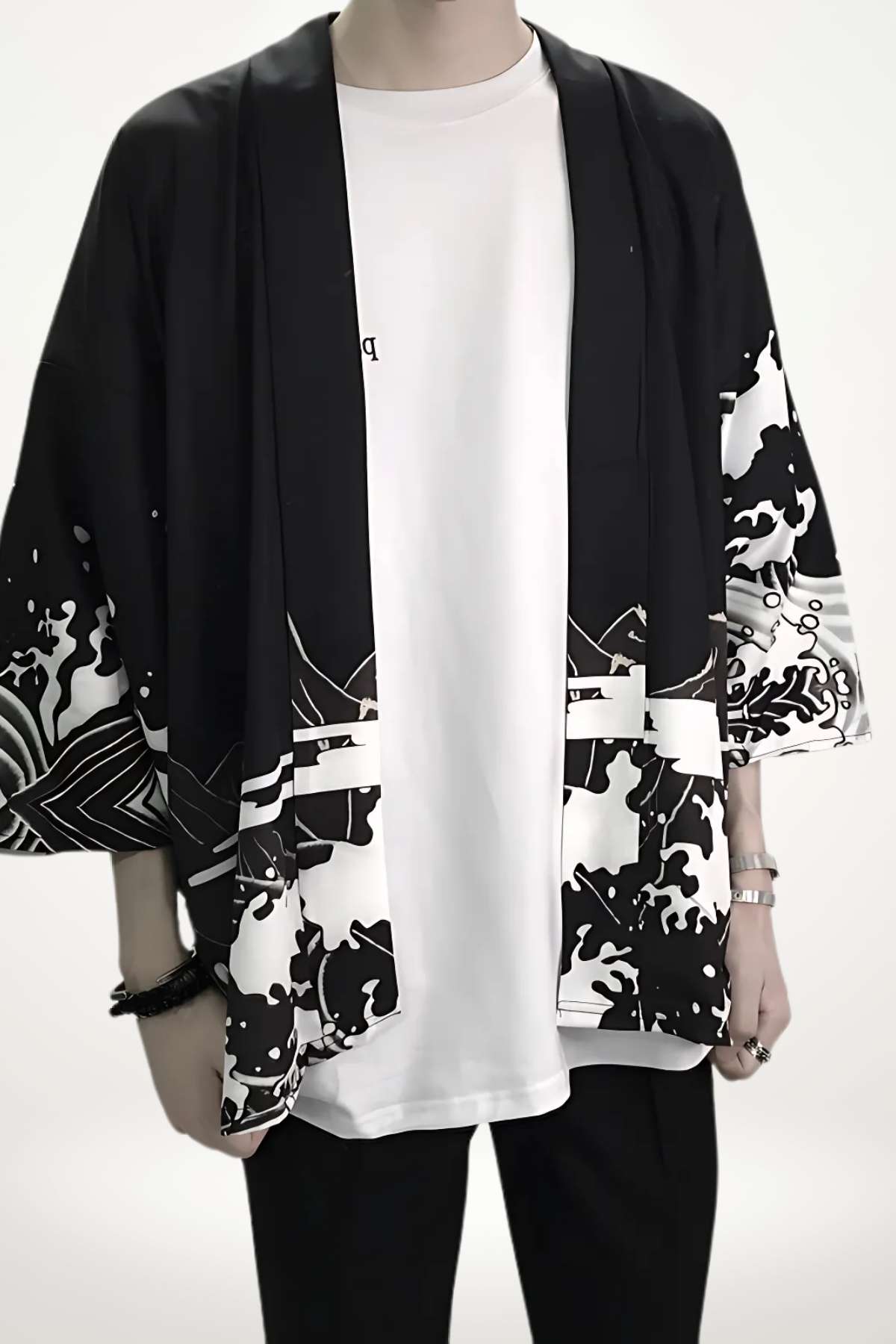 Homme portant un kimono noir et blanc avec motifs graphiques, sur un t-shirt blanc et un pantalon noir