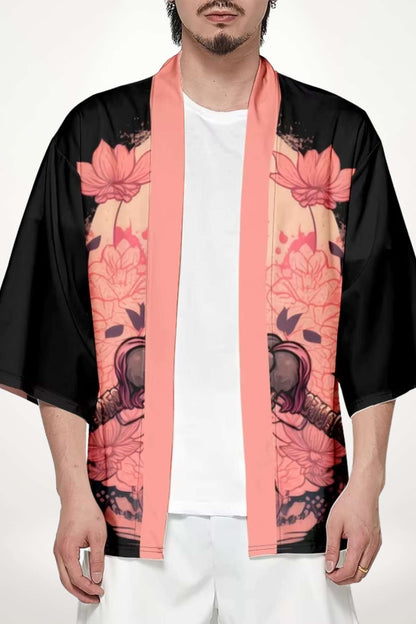 Homme portant un kimono noir et rose avec des motifs floraux, se tenant debout sur fond neutre