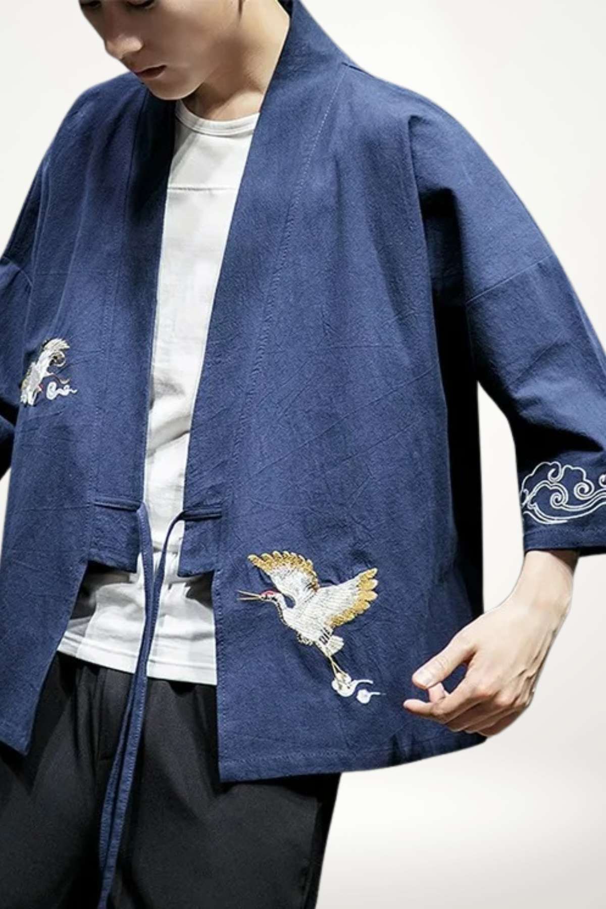 Homme portant un kimono japonais bleu avec des broderies de grues et des motifs nuageux sur les manches