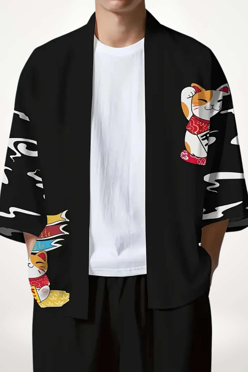 Homme portant un kimono noir avec motifs colorés de chats et vagues, sur fond neutre