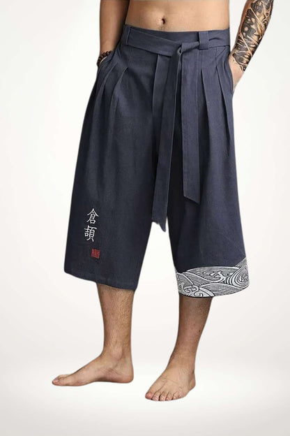 Pantalon kimono homme en tissu bleu foncé, avec un motif blanc sur le bas et une taille ceinturée
