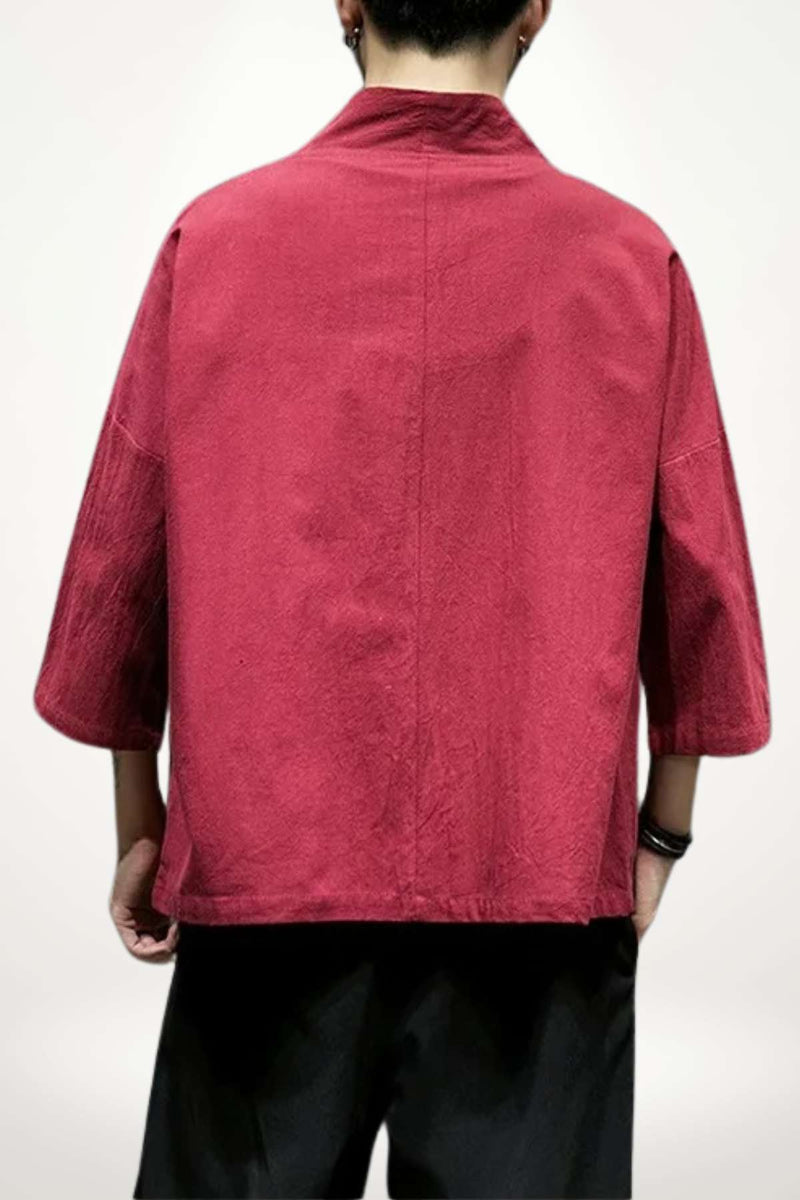Blazer kimono rouge en tissu texturé, manches larges, porté par un homme de dos sur fond neutre