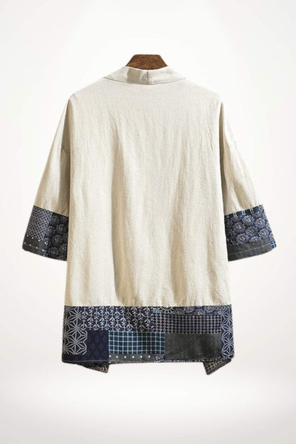 Kimono homme en tissu beige avec des motifs bleus et noirs sur les manches, affichant une esthétique moderne et traditionnelle