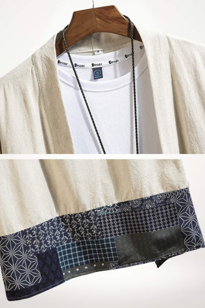Un kimono homme beige avec des motifs variés en bleu, suspendu sur un cintre en bois