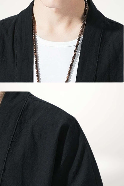 Haut noir en tissu léger avec un col ouvert, porté sur un t-shirt blanc, décoré d'un collier en perles