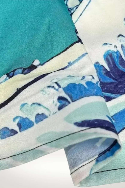 Détail d'un tissu avec motifs floraux bleus et verts sur fond blanc, offrant une texture légère et fluide