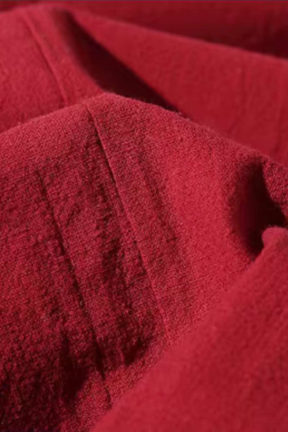 Tissu rouge texturé avec des plis marqués, évoquant un kimono moderne aux accents traditionnels