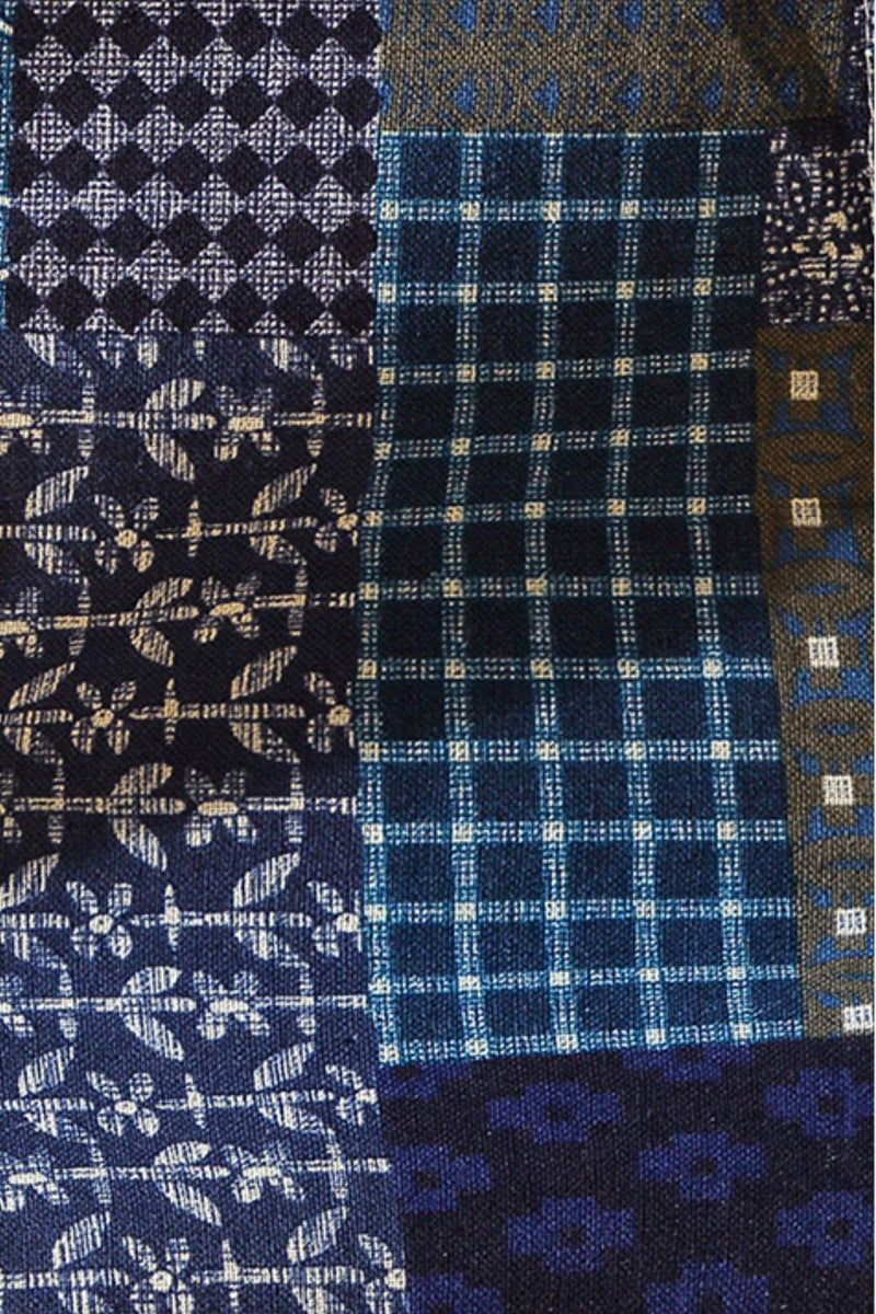 Tissu en patchwork avec motifs floraux et carreaux, dominé par des nuances de bleu et de noir