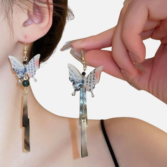 Boucles d'oreilles en forme de papillon, ornées de motifs asiatiques et de perles, suspendues à un fond pastel. Kimono femme.