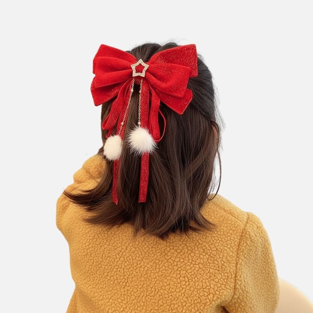 Un nœud rouge scintillant avec des pompons blancs et des rubans, porté sur des cheveux bruns, devant un fond neutre