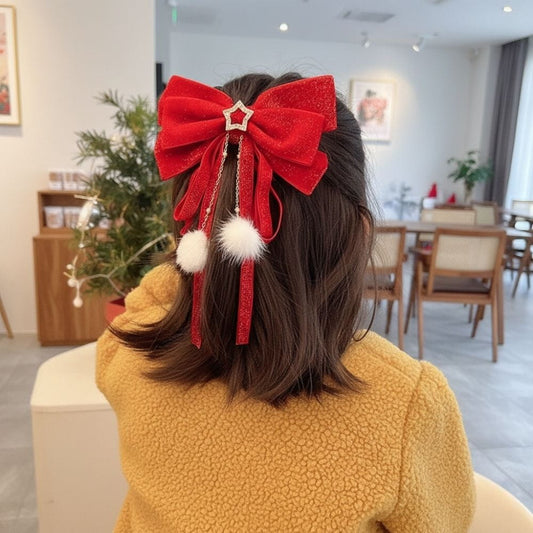 Un nœud en satin rouge scintillant avec des pompons blancs, porté sur des cheveux bruns, dans un décor moderne