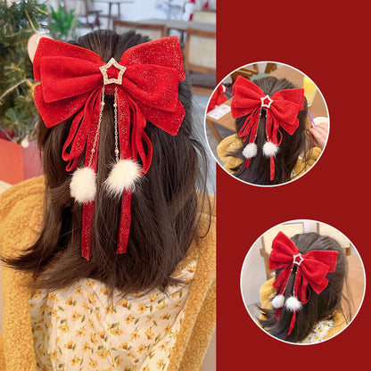 Un grand nœud rouge pailleté orné de pompons blancs et d'une étoile, attaché à des cheveux longs