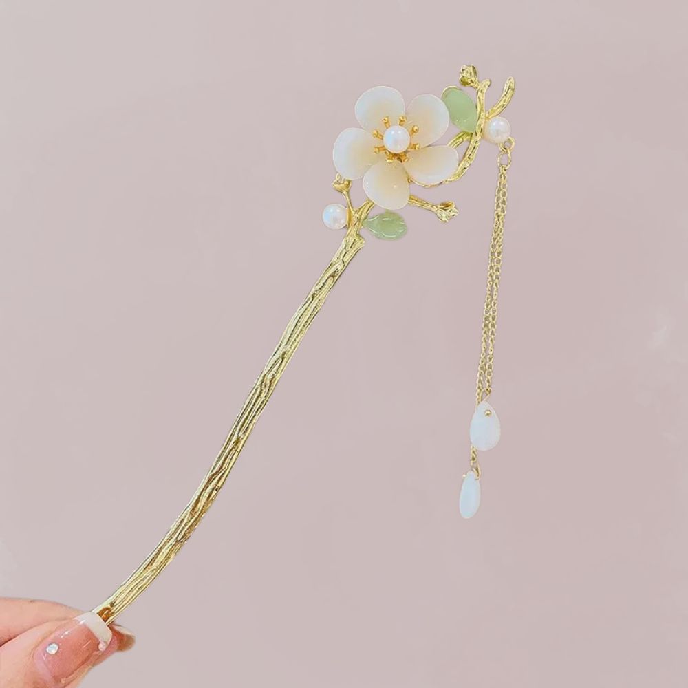 Épingle à cheveux dorée ornée d'une fleur blanche et verte, avec des perles et une chaîne délicate