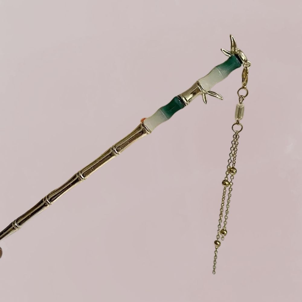 Peigne en bambou avec motifs délicats, chaîne dorée suspendue, sur fond pastel doux