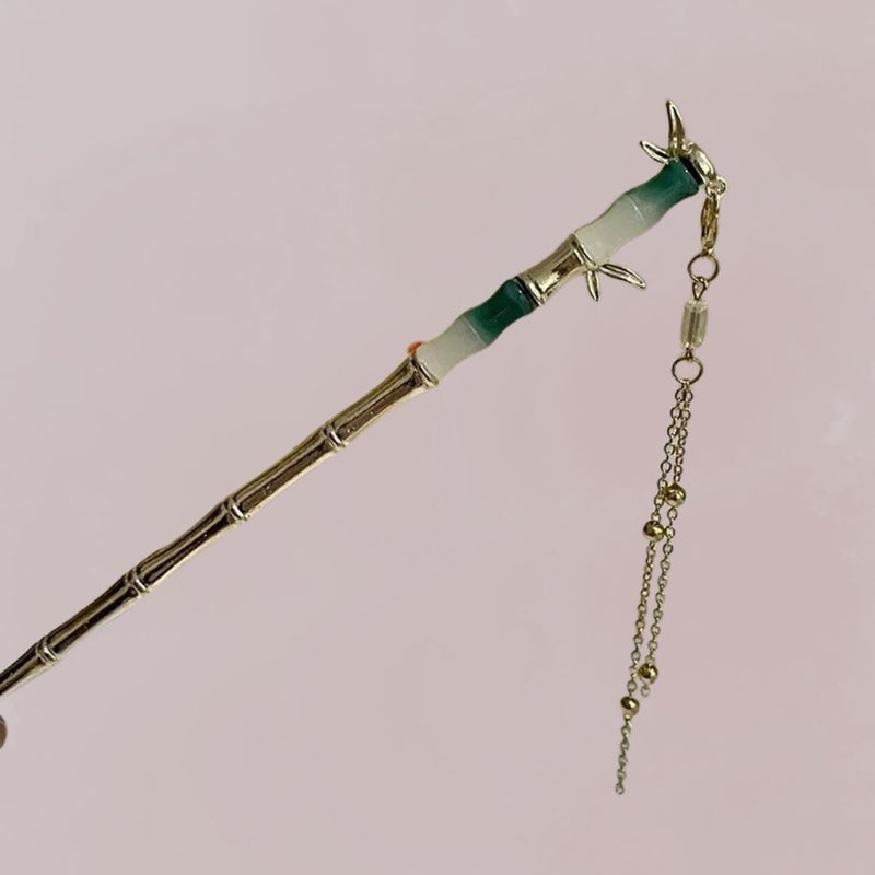 Peigne en bambou avec motifs délicats, chaîne dorée suspendue, sur fond pastel doux