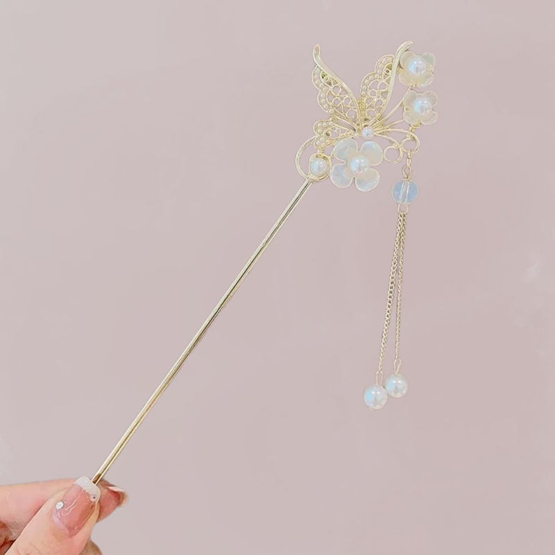 Bijou de cheveux doré en forme de papillon avec fleurs nacrées et perles suspendues sur fond rose